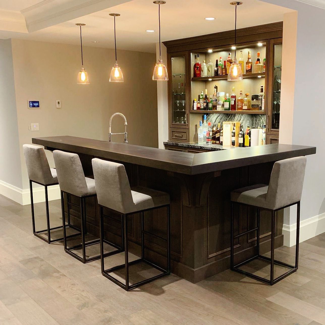 Custom dark walnut bar with pendant lights and built-in shelving