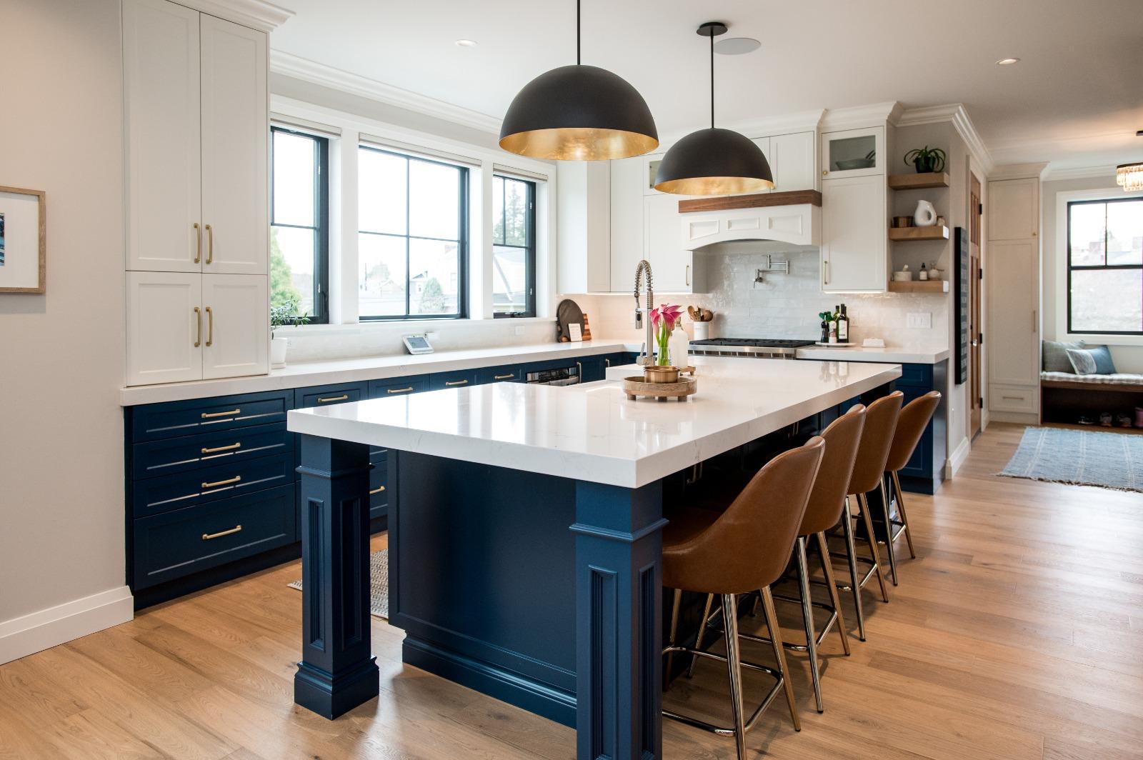 Open kitchen with navy island, white cabinetry and bar seating connected to living space