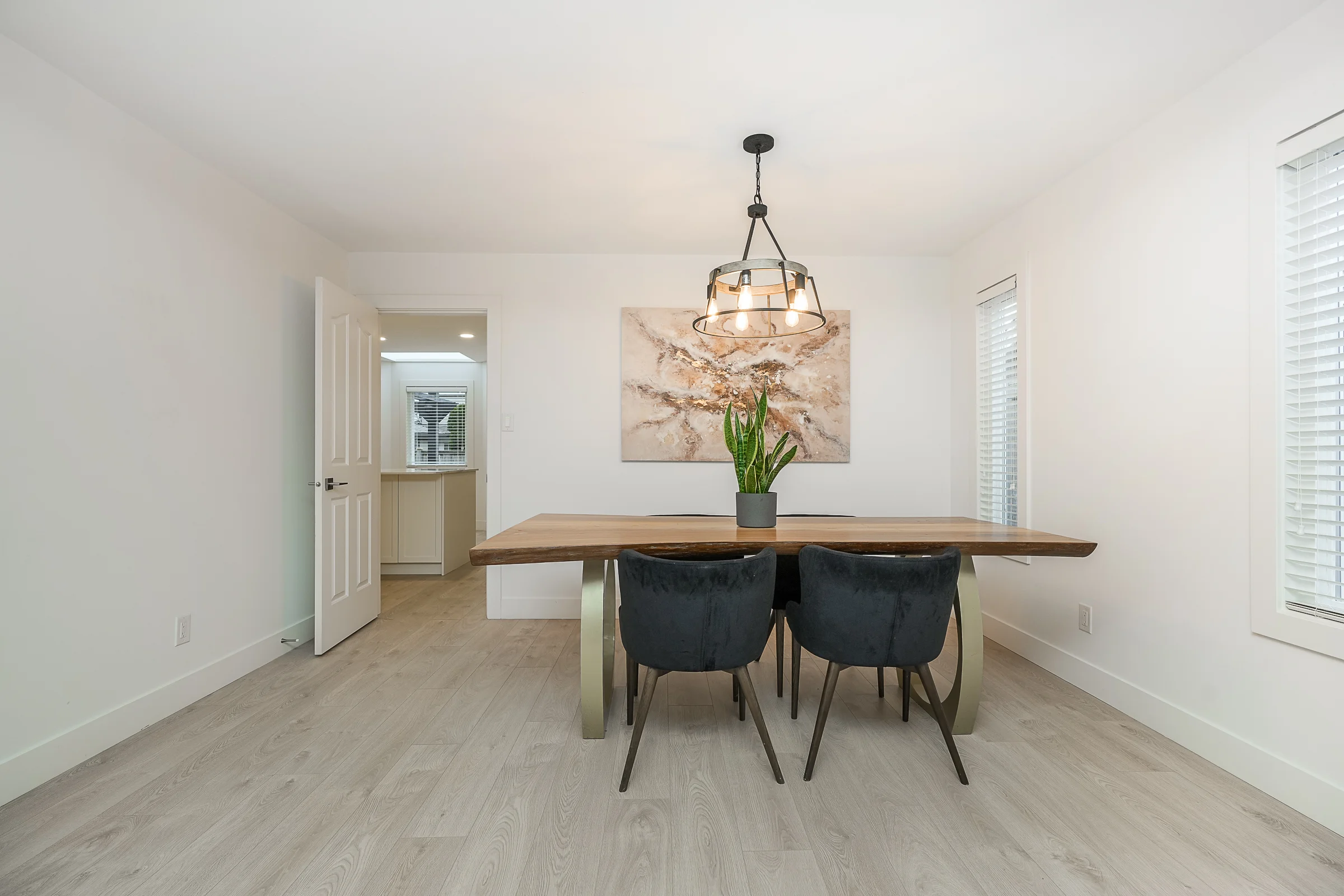 Custom live-edge wood dining table with sculpted brass base and velvet chairs
