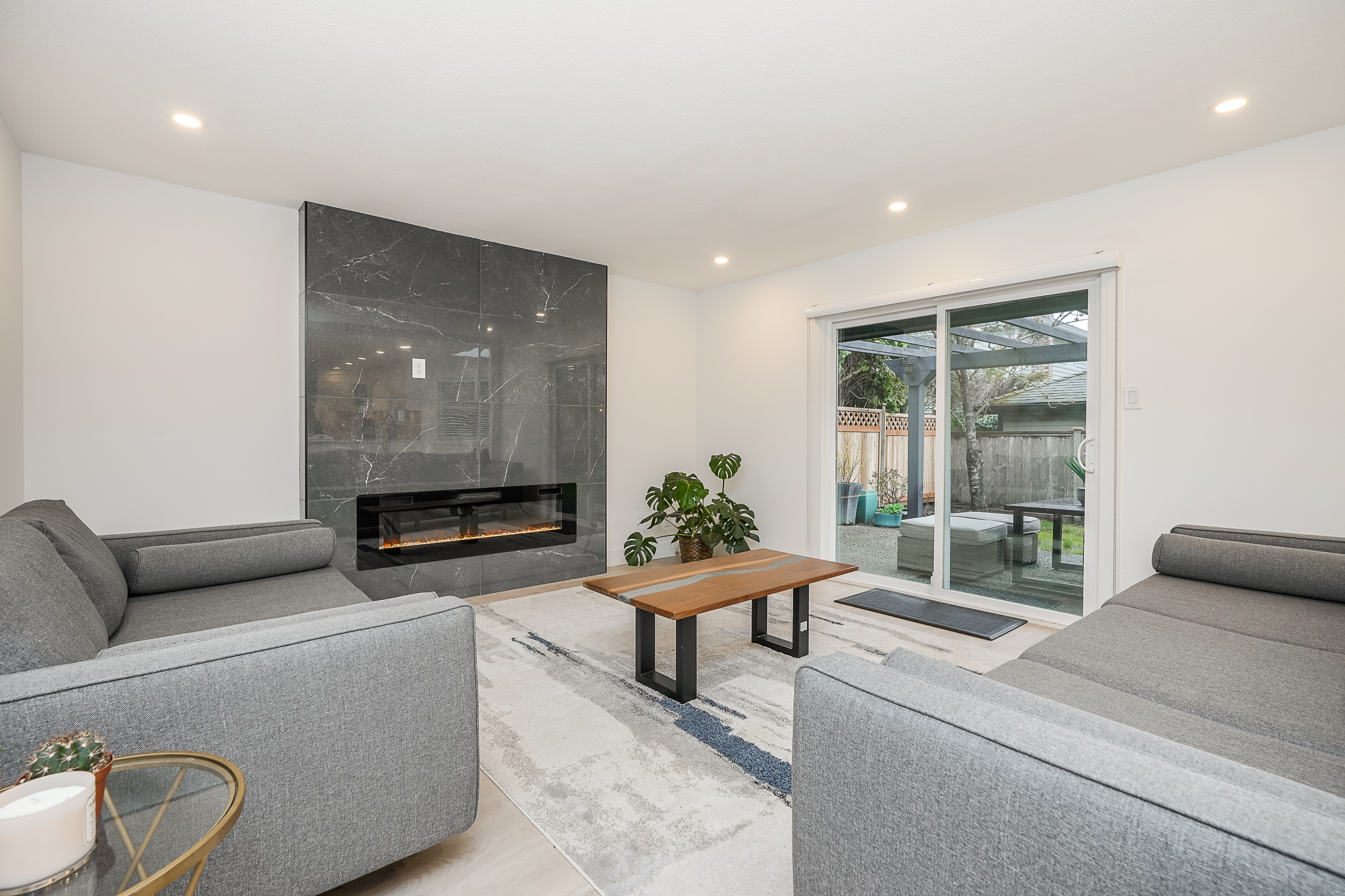Lower-level living with floor-to-ceiling marble fireplace and grey sectionals